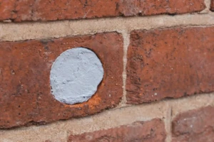 Hole in a brick wall patched with Flexi Armour